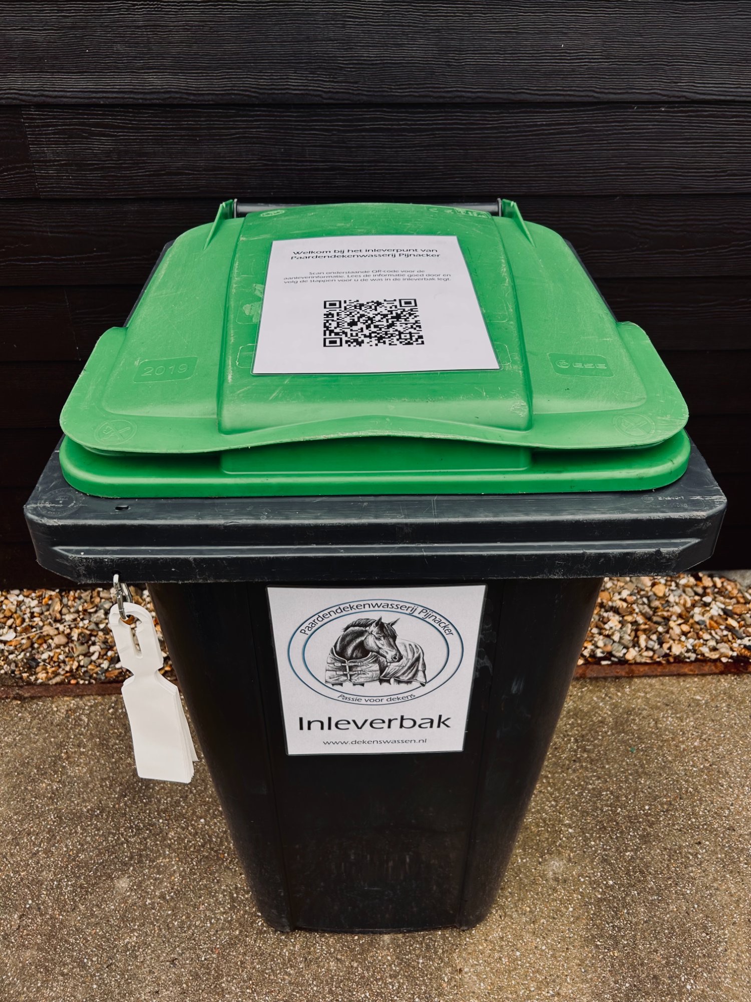 Inleverbak van Paardendekenwasserij Pijnacker, met qr-code en labels
